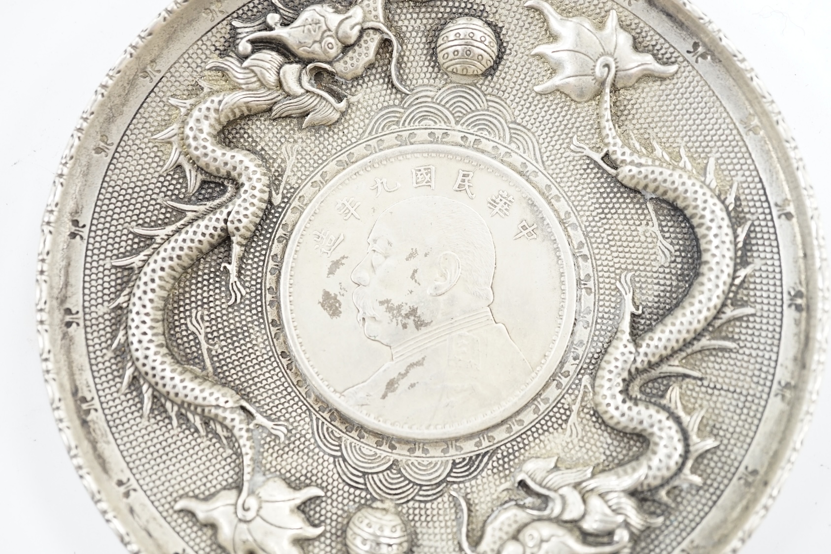 A Chinese white metal dish inset with Yuan Shikai coin, 10.1cm. Condition - fair